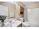 Cozy bathroom features a shower-tub combo, storage cabinet, and a stylish decorative flower patterned shower curtain at 304 S Smith St, Clayton, NC 27520