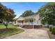 Charming single-story home with a cozy front porch, mature trees, and a well-kept lawn at 304 S Smith St, Clayton, NC 27520