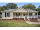 Charming home with a cozy front porch, white railings, and brick accents at 304 S Smith St, Clayton, NC 27520