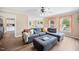 Comfortable living room featuring a large sectional sofa, modern ceiling fan, and bright windows at 304 S Smith St, Clayton, NC 27520