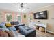 Cozy living room featuring a gray sectional sofa, large TV, and natural light at 304 S Smith St, Clayton, NC 27520