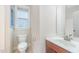 Cozy bathroom with a toilet, a window, and a vanity with sink and faucet under a large mirror at 307 Millbrook Dr, Pittsboro, NC 27312