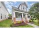 Inviting two-story home featuring a covered front porch, brick accents, and well-maintained landscaping at 307 Millbrook Dr, Pittsboro, NC 27312