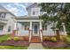 Inviting two-story home showcasing a charming front porch, brick base, and freshly landscaped garden beds at 307 Millbrook Dr, Pittsboro, NC 27312