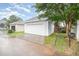 Detached garage featuring a clean, white door, complemented by neat landscaping and a paved driveway at 307 Millbrook Dr, Pittsboro, NC 27312