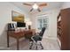 This staged home office shows a stylish desk, chair, and bookshelf, complemented by a ceiling fan and natural light at 307 Millbrook Dr, Pittsboro, NC 27312