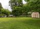 Large grassy backyard with a shed, ideal for outdoor activities and storage at 307 Sunset Dr, Elon, NC 27244