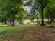 Lush backyard featuring mature trees and a shed, offering a serene outdoor space at 307 Sunset Dr, Elon, NC 27244