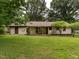 Green backyard featuring covered back porch and mature trees, ideal for entertaining at 307 Sunset Dr, Elon, NC 27244