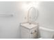 Bright bathroom with a white vanity, oval mirror, and nearby toilet at 307 Sunset Dr, Elon, NC 27244