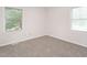 A bright bedroom with neutral carpet and two windows at 307 Sunset Dr, Elon, NC 27244