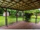 Enclosed brick patio offering a view of the spacious backyard with a shed, ideal for relaxing outdoors at 307 Sunset Dr, Elon, NC 27244