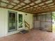 Covered patio with brick flooring, lattice accent, and backyard access at 307 Sunset Dr, Elon, NC 27244