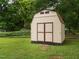 Outdoor storage shed with double doors, providing ample space for tools and equipment in a grassy yard at 307 Sunset Dr, Elon, NC 27244