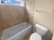 Clean bathroom featuring a tiled shower-tub combination and a modern toilet, illuminated by a bright window at 3116 Kirby St, Durham, NC 27713