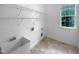 Functional laundry room with tile floor, utility sink, and shelving, conveniently located near a bright window at 3116 Kirby St, Durham, NC 27713