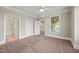 Bright bedroom with neutral carpet, crown molding, and doorways to an ensuite bathroom and closet at 324 Waterford Lake Dr, Cary, NC 27519