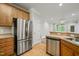Well-equipped kitchen with stainless steel appliances, wooden cabinets and a view of the living area at 324 Waterford Lake Dr, Cary, NC 27519
