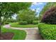 Sidewalk with manicured landscaping featuring grass, bushes, and trees at 324 Waterford Lake Dr, Cary, NC 27519