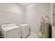 Functional laundry room with washer, dryer, shelving, and ample storage space for household needs at 324 Waterford Lake Dr, Cary, NC 27519