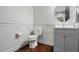 Clean half bathroom with white wainscoting, modern fixtures, and wood flooring at 369 Roberts Ridge Dr, Cary, NC 27513