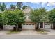Charming townhome featuring a two-car garage, stone accents, and lush landscaping at 369 Roberts Ridge Dr, Cary, NC 27513