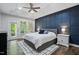 Comfortable bedroom featuring a tray ceiling, navy accent wall, large windows, and stylish decor at 369 Roberts Ridge Dr, Cary, NC 27513