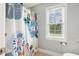 Bathroom showing a floral shower curtain and a window with a view outside at 40 Breckenridge Pl, Dunn, NC 28334