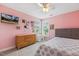Pink bedroom with desk, bed, dresser, ceiling fan, and wall-mounted TV at 40 Breckenridge Pl, Dunn, NC 28334