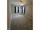 Bright bedroom featuring two windows with dark curtains and neutral carpeting for a cozy ambiance at 401 Coalinga Ln # 106, Raleigh, NC 27610