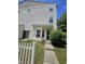 Two-story townhome featuring a private entrance and a well-manicured lawn with a charming white picket fence at 401 Coalinga Ln # 106, Raleigh, NC 27610