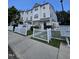 A cream-colored townhouse complex featuring a white picket fence and well-maintained landscaping at 401 Coalinga Ln # 106, Raleigh, NC 27610