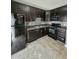 Modern kitchen featuring dark cabinets, sleek black appliances, and stylish backsplash at 401 Coalinga Ln # 106, Raleigh, NC 27610