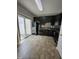 Efficient kitchen featuring black appliances, dark cabinetry, and access to outdoor area at 401 Coalinga Ln # 106, Raleigh, NC 27610
