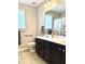 Bright bathroom featuring a double sink vanity with dark cabinets and neutral walls and tile at 411 Joneshaven Dr, Fuquay Varina, NC 27526