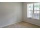 Minimalist bedroom with neutral walls, carpet, and natural light from a window with white blinds at 411 Joneshaven Dr, Fuquay Varina, NC 27526