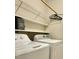 Efficient laundry room equipped with modern washer and dryer units and storage shelves at 411 Joneshaven Dr, Fuquay Varina, NC 27526