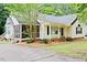 Charming, light yellow home featuring a cozy porch and lush landscaping at 419 Jera Dr, Garner, NC 27529