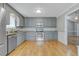 Well-appointed kitchen with gray cabinetry, stainless steel appliances, and hardwood flooring at 419 Jera Dr, Garner, NC 27529