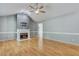 Spacious living room with a cozy fireplace, wood floors, and a modern ceiling fan at 419 Jera Dr, Garner, NC 27529