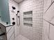 Close up of luxurious, tiled shower with black fixtures and built-in niches at 419 Jera Dr, Garner, NC 27529