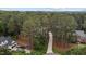 Aerial view of the property with a long driveway surrounded by a dense forest and some neighboring homes at 4416 Thistlehill Ct, Raleigh, NC 27616