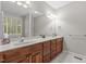 Bright bathroom with a double vanity, white countertops, and ample storage space in wood cabinets at 4416 Thistlehill Ct, Raleigh, NC 27616