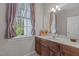 Charming bathroom with wood cabinets, a large window, and serene natural light at 4416 Thistlehill Ct, Raleigh, NC 27616