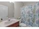 Bright bathroom featuring a sink with vanity, toilet with leafy shower curtain, and a neutral paint scheme at 4416 Thistlehill Ct, Raleigh, NC 27616