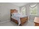 Charming bedroom with a wooden frame bed, soft blue quilt, and bright windows with decorative curtains at 4416 Thistlehill Ct, Raleigh, NC 27616