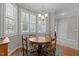 Sun-drenched breakfast nook featuring a round wood table, shuttered windows, and an elegant chandelier at 4416 Thistlehill Ct, Raleigh, NC 27616
