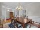 Elegant dining room with a large wooden table, decorative lighting, and classic wainscoting at 4416 Thistlehill Ct, Raleigh, NC 27616