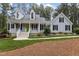 Charming two-story home with a welcoming front porch, complemented by landscaped grounds and a lush green lawn at 4416 Thistlehill Ct, Raleigh, NC 27616
