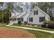 Charming light blue home featuring a covered porch, black shutters and manicured landscaping at 4416 Thistlehill Ct, Raleigh, NC 27616